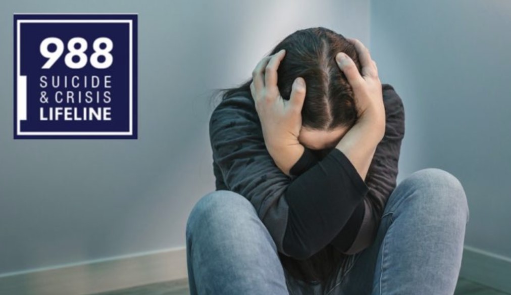 Image of person holding head by knees